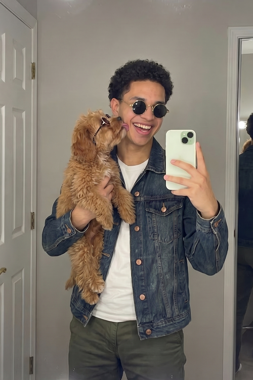 man in denim jacket hold small dog wearing sunglasses